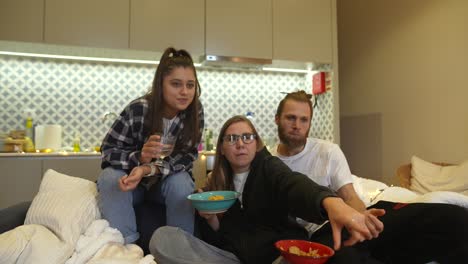 amigos viendo películas o televisión y comiendo bocadillos en casa