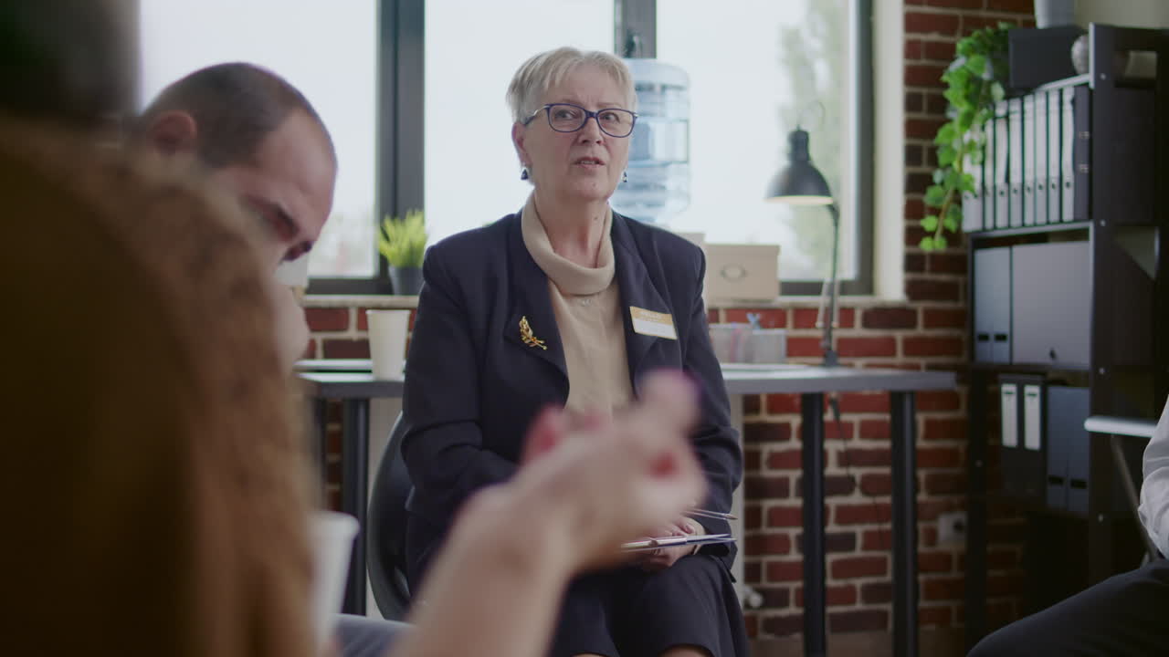 Woman therapist listening to people with addiciton problems at aa group meeting