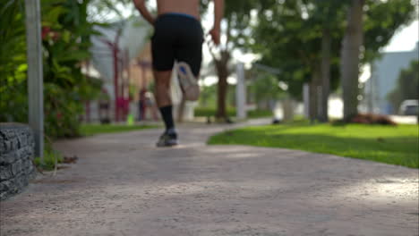 slow motion of a shirtless man running sprinting away from the camera getting progressively out of focus