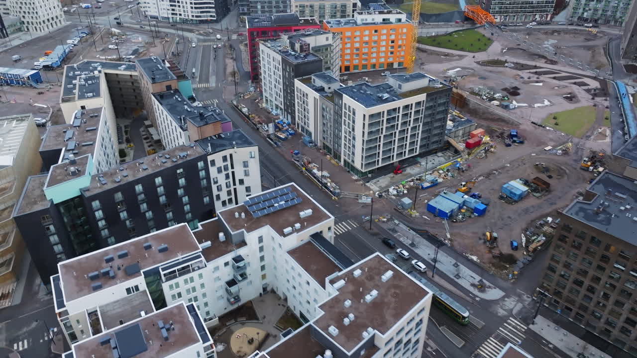 Aerial view following a tram on the streets of Jatkasaari, gloomy day in Helsinki