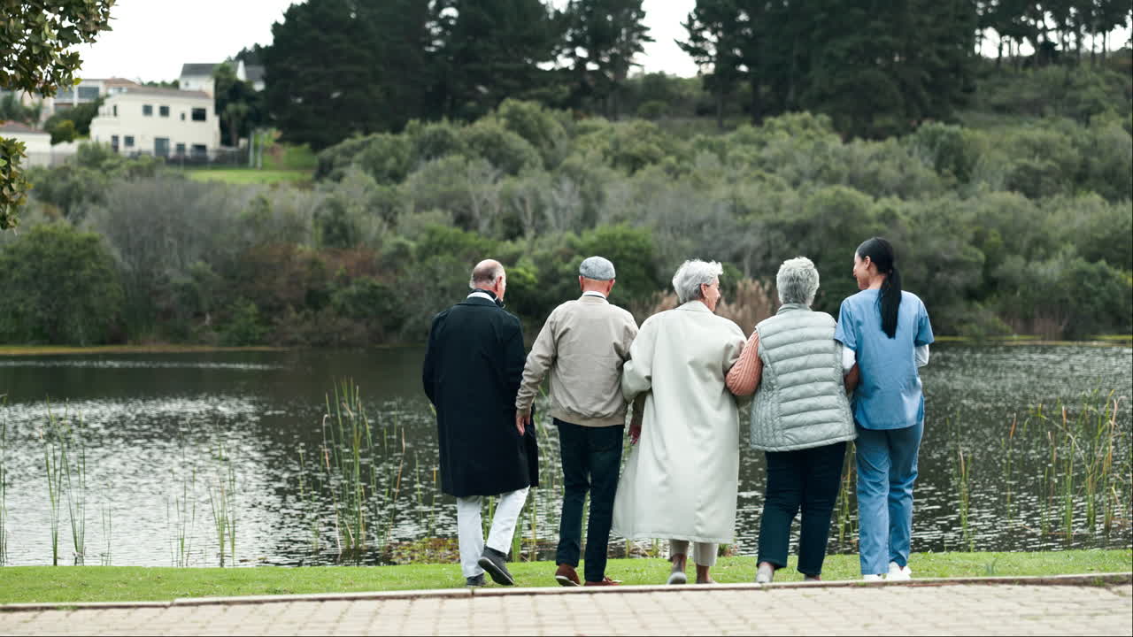 Group of Senior Citizens Enjoying a Walk in the Park with a Nurse