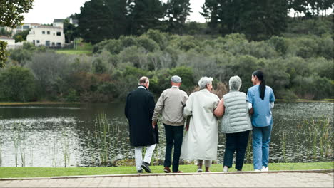 group of senior citizens enjoying a walk in the park with a nurse