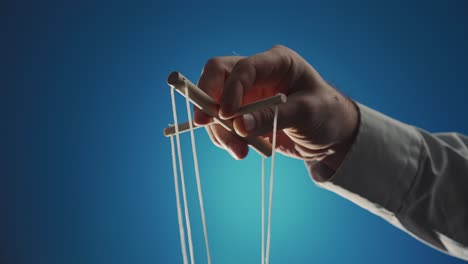 Hand Holding Puppet Strings