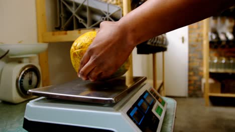 personal masculino pesando la papaya en la máquina de pesaje 4k