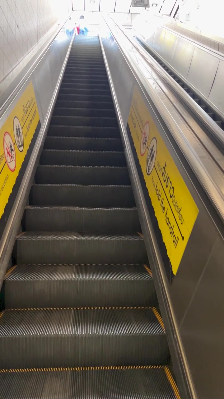 Synsvinkeloptagelse af en tur op ad en tom metro-rulletrappe mod en lys stationsudgang, med jævn opadgående kamerabevægelse