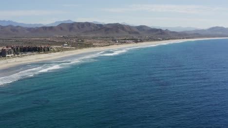 toma cinematográfica súper genial de los acantilados cerca de la playa de los cerritos en un día soleado con las olas de agua azul rompiendo las rocas en méxico