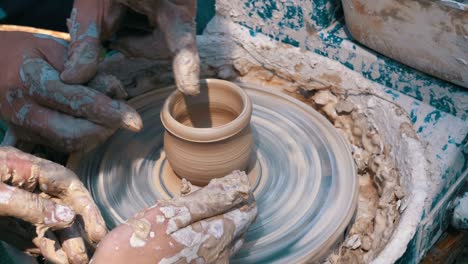 hands of the master potter and vase of clay on the potter's wheel