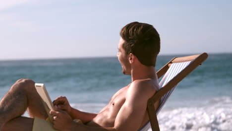 a man is reading a book and smiling