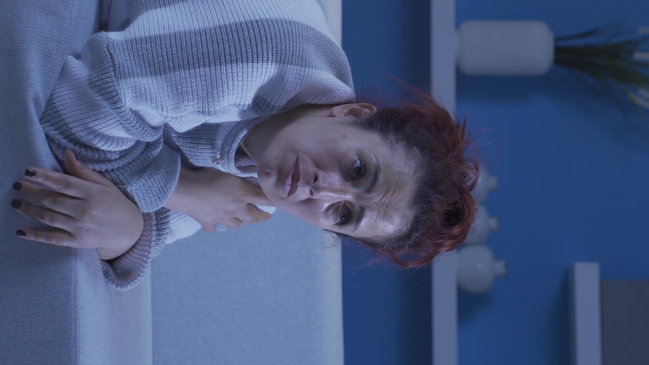el video vertical de la mujer acostada en el sofá está llorando.