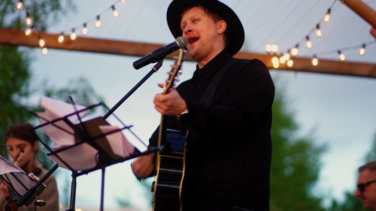 Musiker singt und spielt Akustikgitarre bei Outdoor-Veranstaltung
