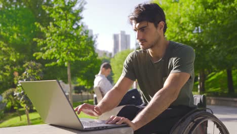 joven discapacitado trabajando con una computadora portátil y ganando, regocijándose.