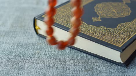 Heiliges-Buch-Koran-Und-Rosenkranz-Auf-Dem-Tisch,-Nahaufnahme