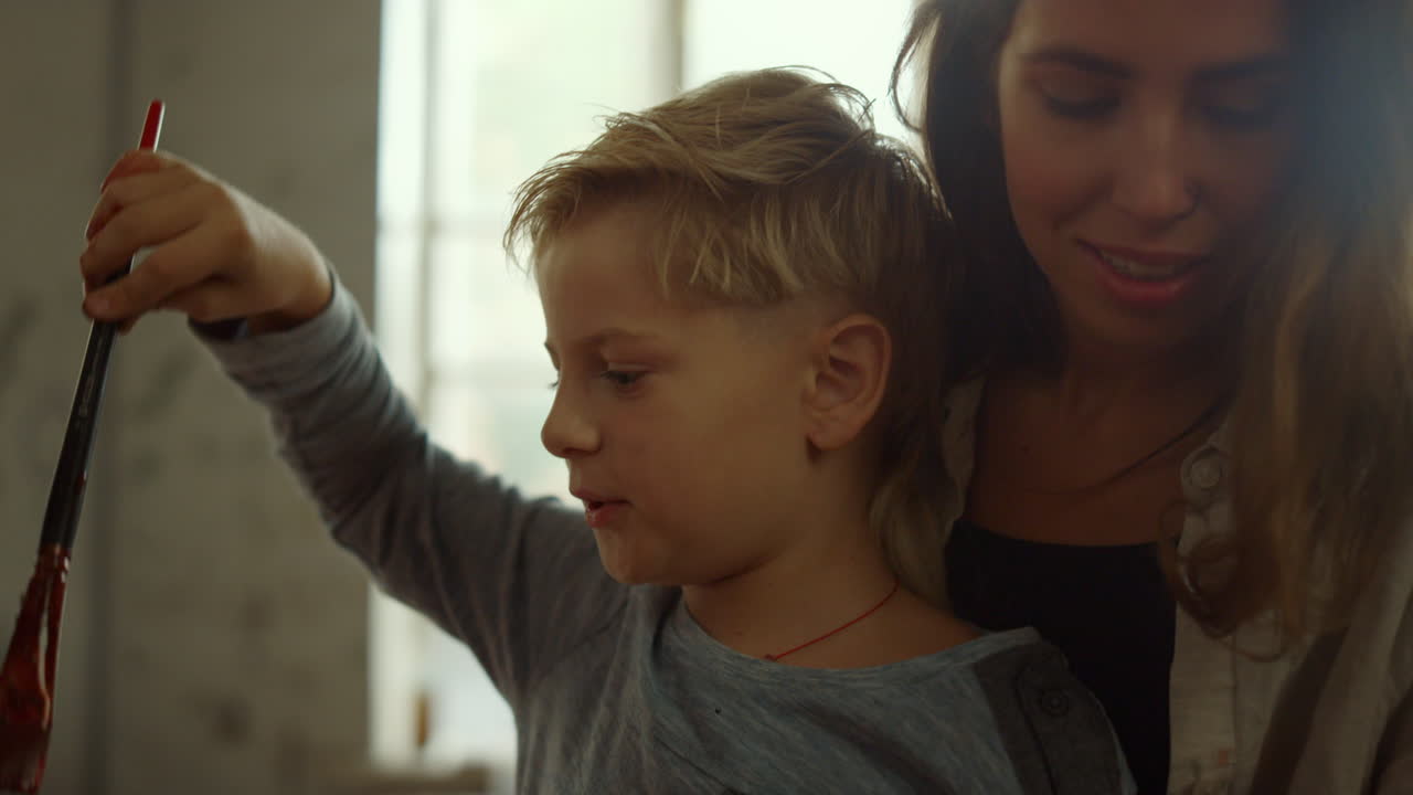 niño y mujer dibujando en el interior, pintora enseñando en un estudio de arte.