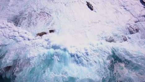 Strong-ocean-waves-crashing-on-the-rockpool-beautiful-reverse-drone-shot-from-the-top