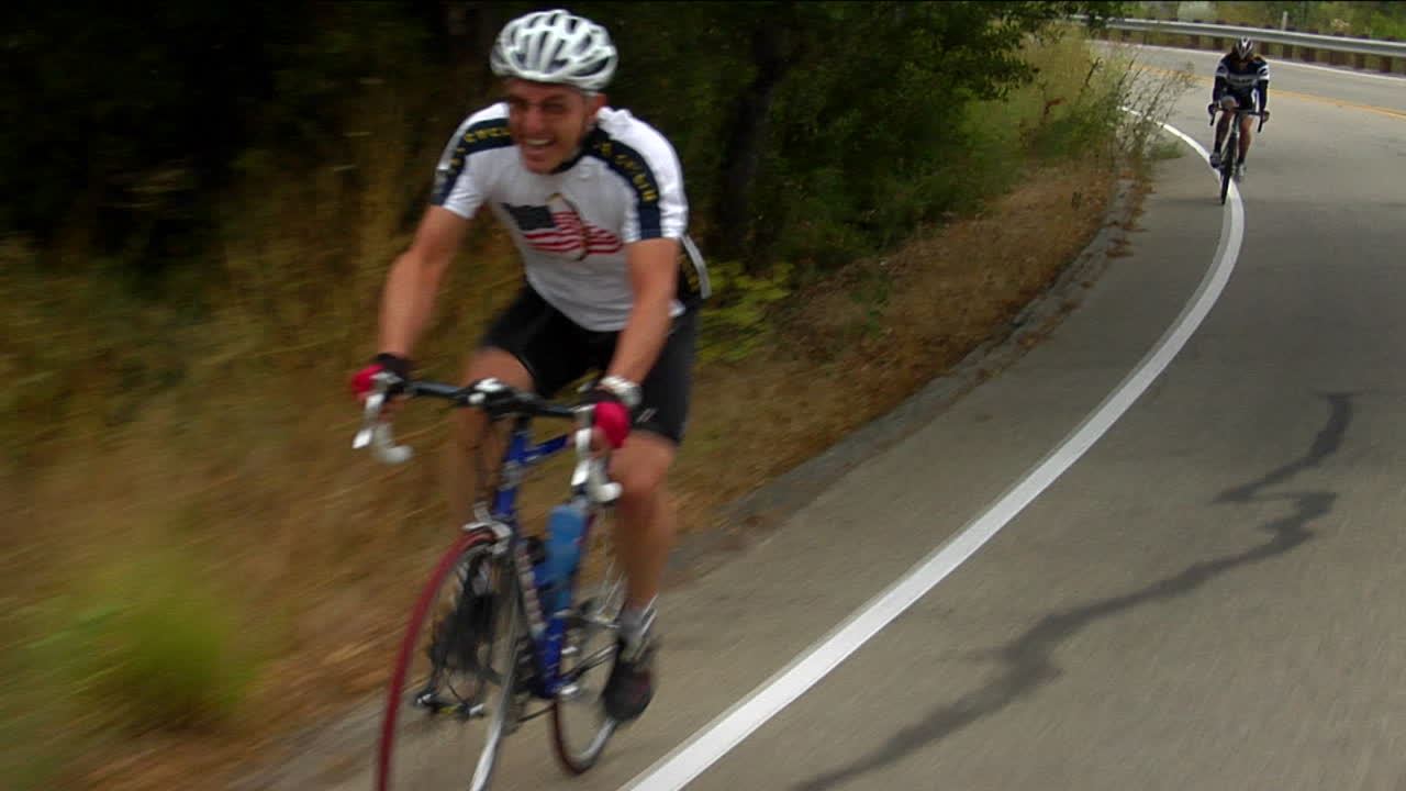 Ciclisti pedalano lungo una curva di montagna