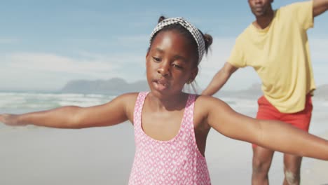 Afroamerikanischer-Vater-Und-Tochter-Mit-Weit-Geöffneten-Armen-Genießen-Am-Strand