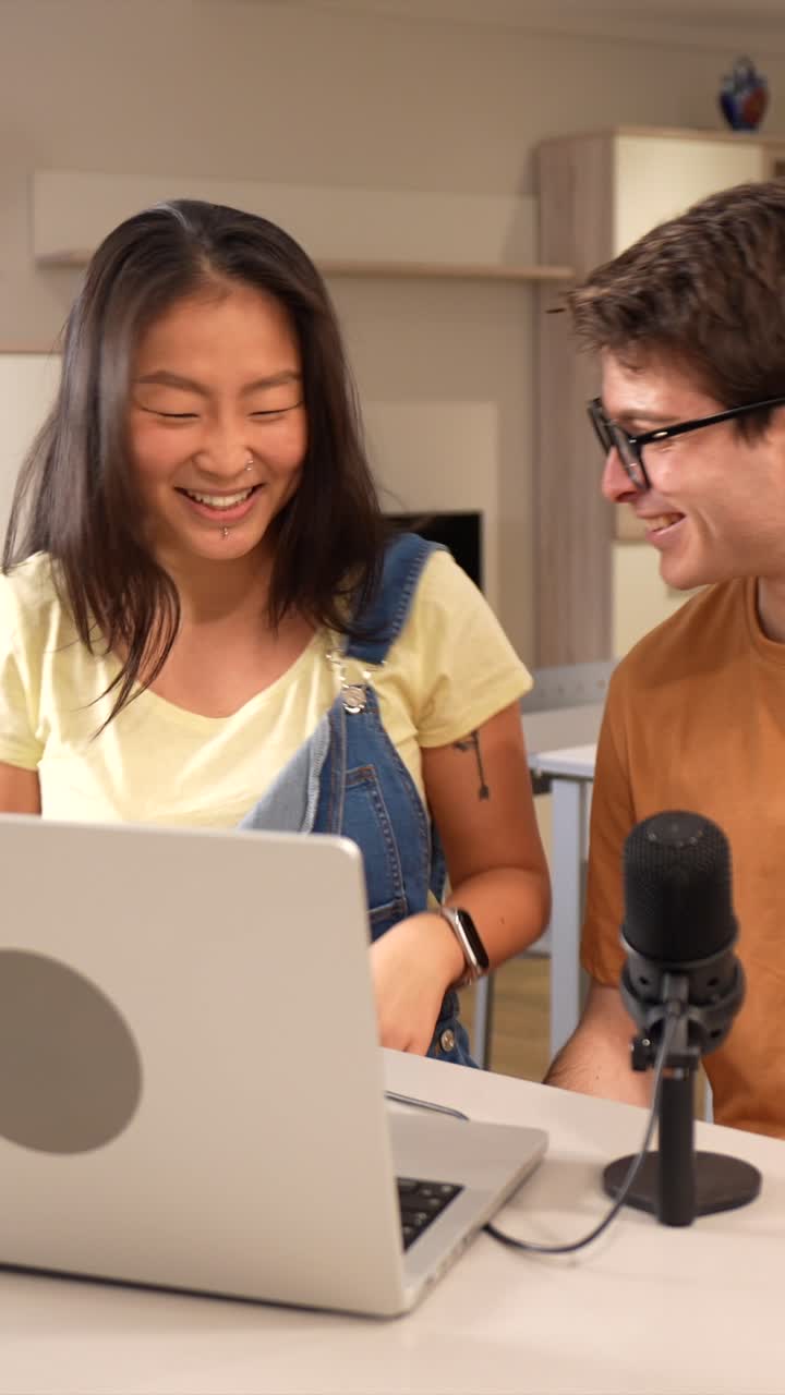 Dos personas grabando un podcast en un portátil