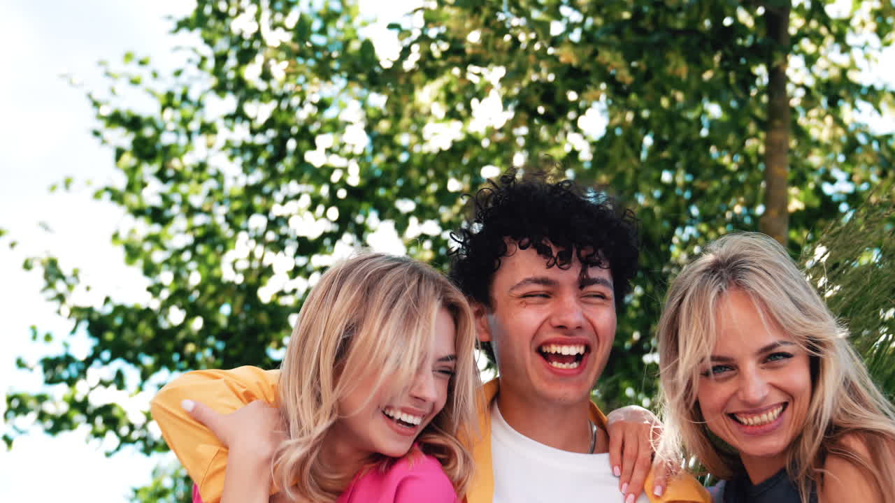 3명의 친구들이 야외에서 웃고 있습니다.