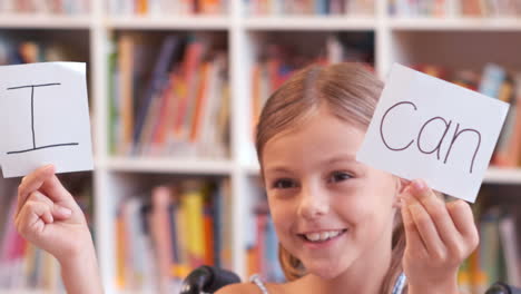 disabled girl showing placard that reads i can in library