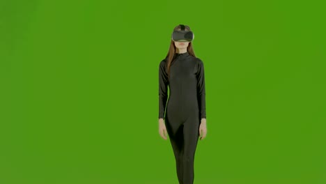 chica atractiva joven modelo de moda con auriculares vr disparado en el estudio de pantalla verde. gesto futurista interactivo. medio s