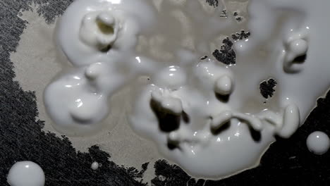 una masa similar a una mancha crece con protuberancias temblorosas, arrojando algo de material en esferas voladoras