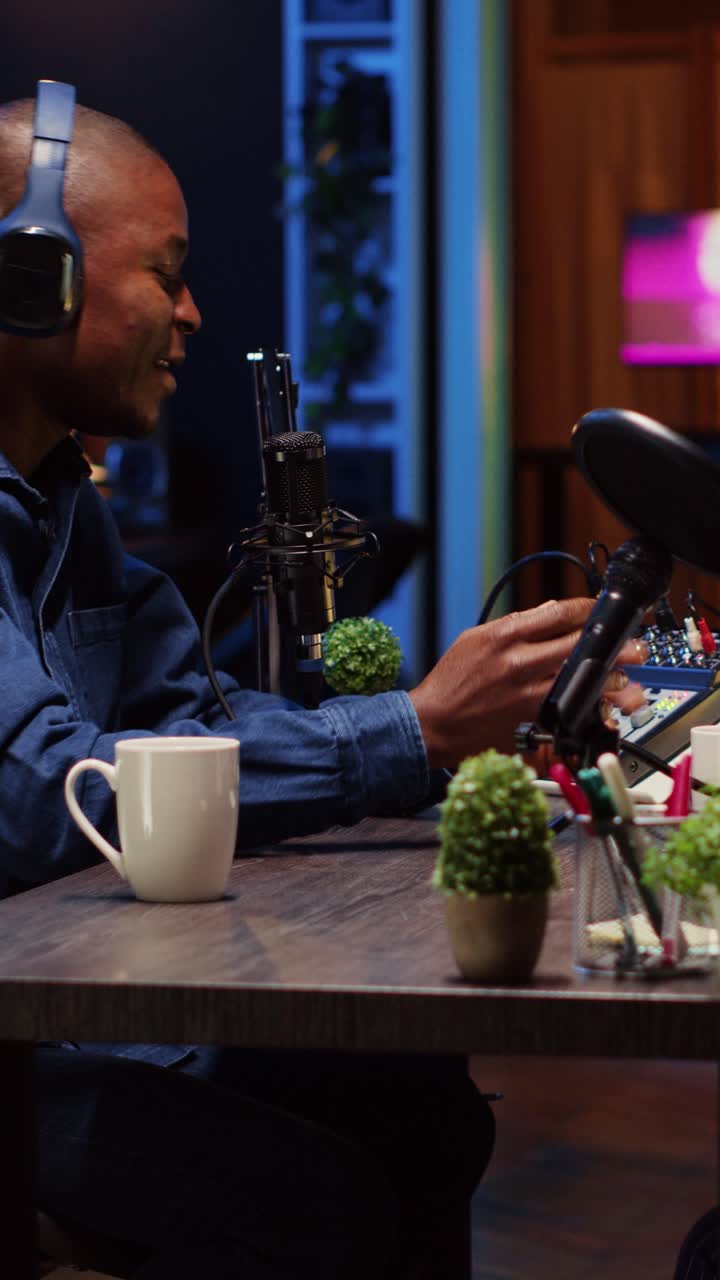 Video verticale di un influencer che registra un podcast con un ospite, utilizzando attrezzature professionali in uno studio domestico