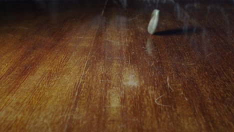 closeup of 1 spanish peseta flipping on wooden table, static, slow