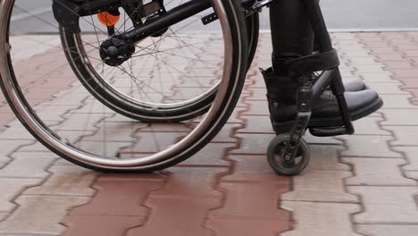 una persona con discapacidad se mueve por la calle en silla de ruedas