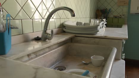 old type kitchen dolly zoom shot revealing the marble sink with some dishes to be washed