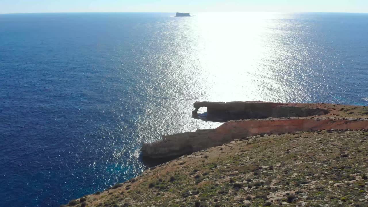 드론은 자연의 바위 위로 돌창과 몰타 지중해에 있는 작은 섬인 필플라를 향해 총을 쐈습니다.
