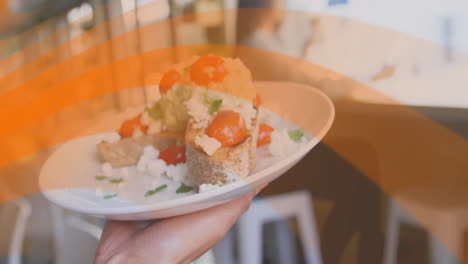 holding plate with bruschetta, hand serving appetizer with tomatoes and cheese