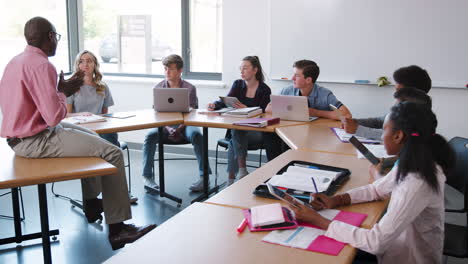 Tutor-De-Secundaria-Sentado-En-El-Escritorio-Y-Enseñando-Clases-Filmadas-En-Cámara-Lenta