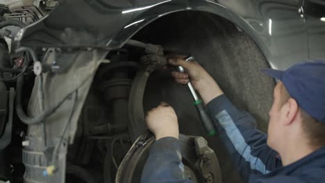 mechanic repairing car suspension