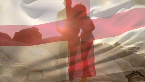 animation of flag of england over african american couple at beach