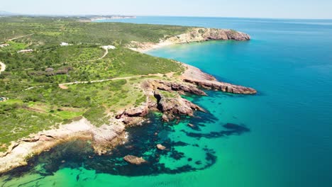 secluded beaches with rugged coastline in amado beach near carrapateira in the algarve region of portugal. aerial drone shot