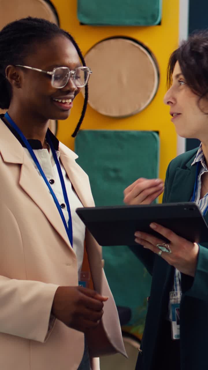 Two Diverse Businesswomen Discussing on Tablet and Shaking Hands