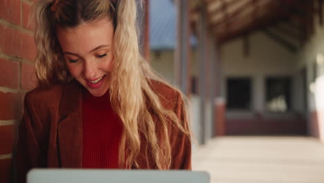 young woman studying on laptop at college campus