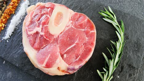 chuleta de filete, romero y especias en la tabla de cortar