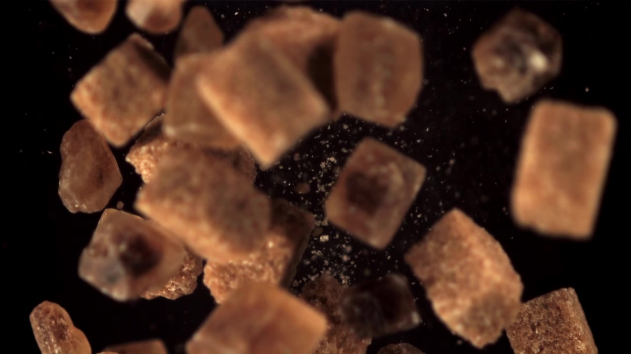 Brown Sugar Cubes and Crystals Falling in Slow Motion