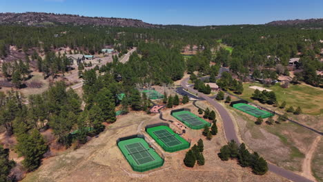castle pines village golf course spring aerial drone colorado pickleball tennis courts club house front range morning gated community neighborhood homes cars roads forward pan up motion