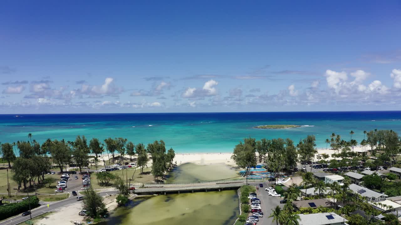 하와이 해안선에서 멀어지는 드론 이 해변을 둘러싼 동네를 드러니다.