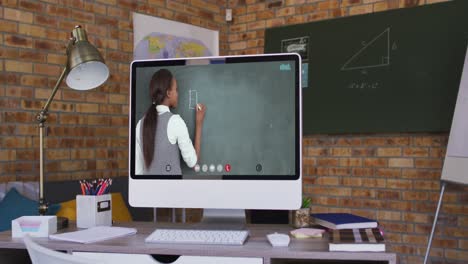 Mixed-race-female-teacher-displayed-on-computer-screen-during-video-call