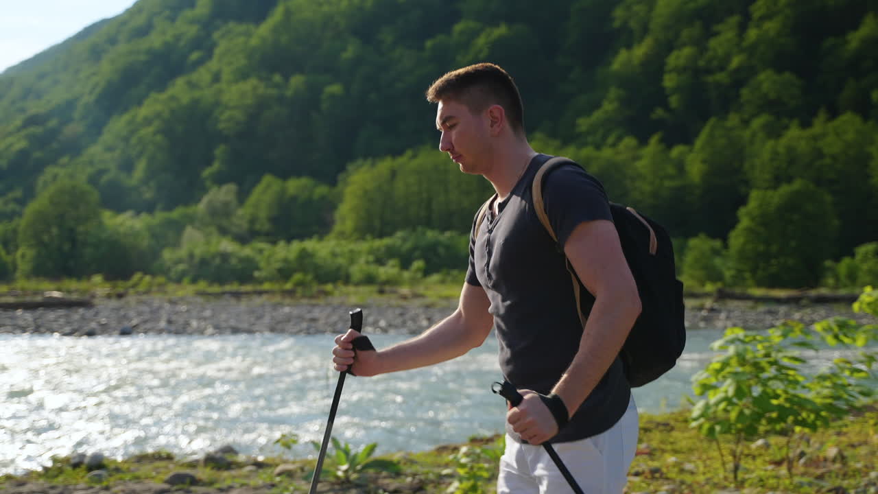 강 근처 의 산 에서 산책 하는 사람