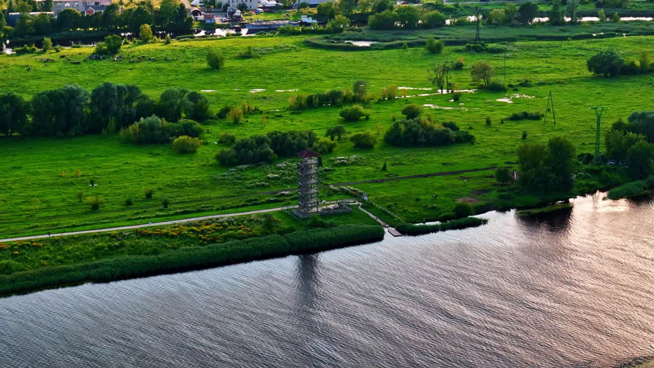 Jelgava observation tower beside Lielupe river in lush green floodplain area