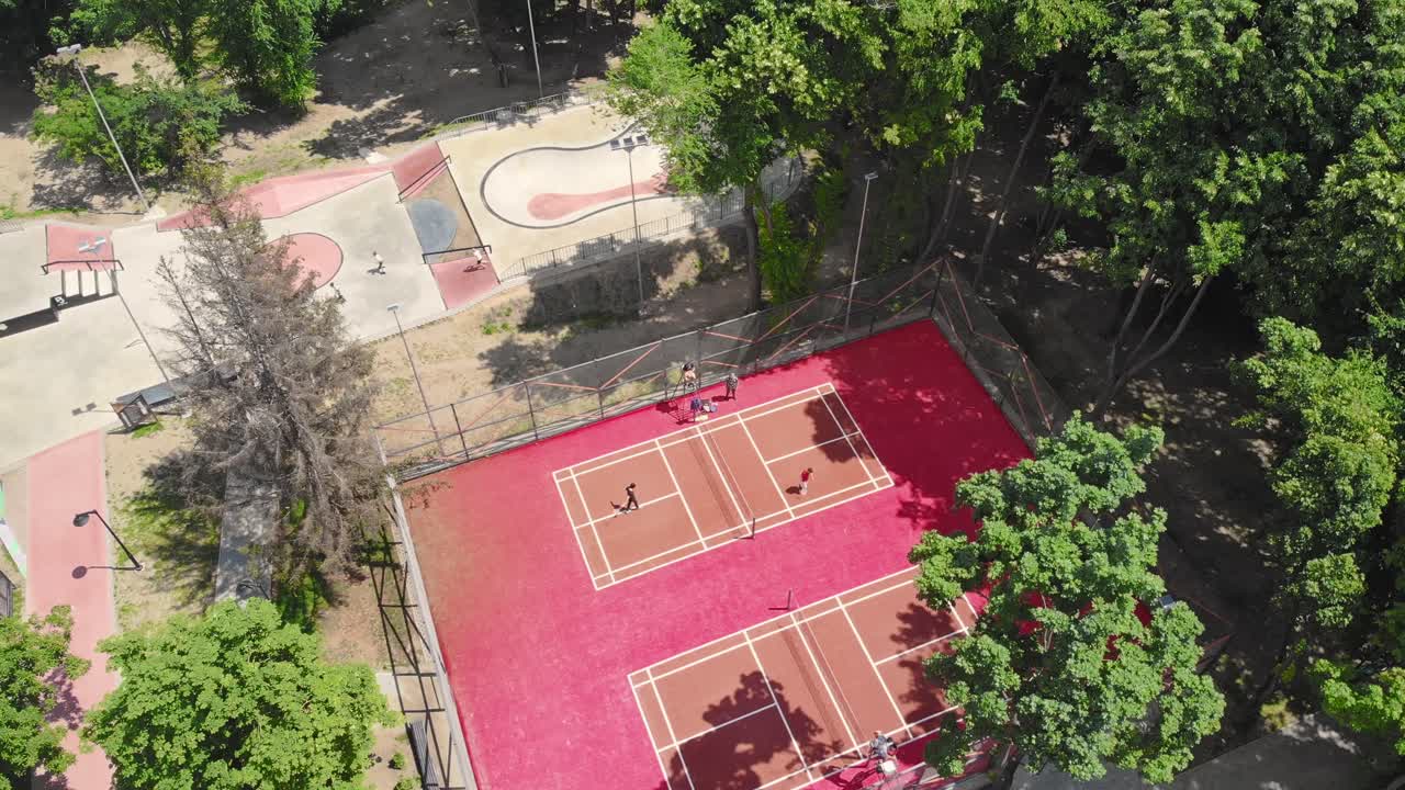 Young boys enjoy volleyball court and skate park near the forest