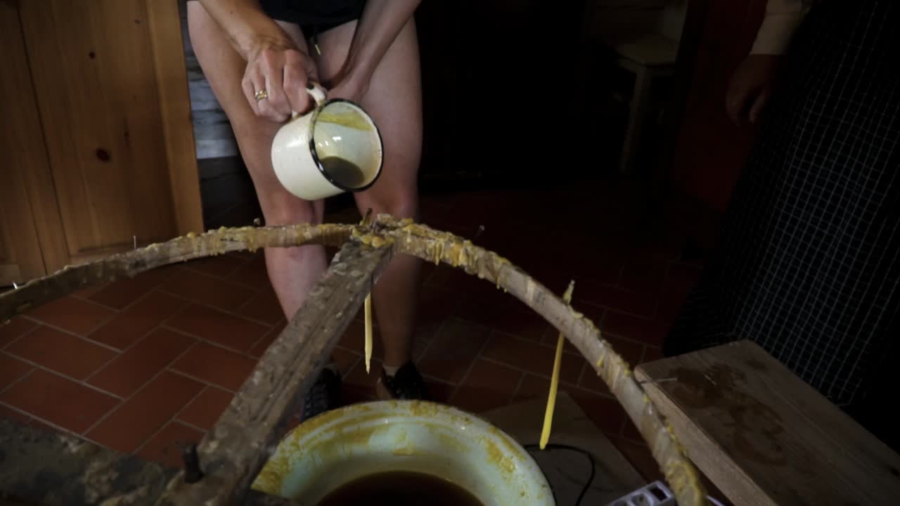 gente haciendo velas con cera caliente en la antigua técnica antigua