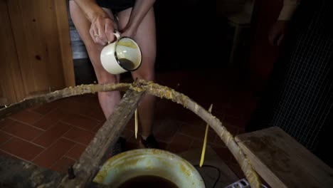 people making candles with hot wax in old ancient technique