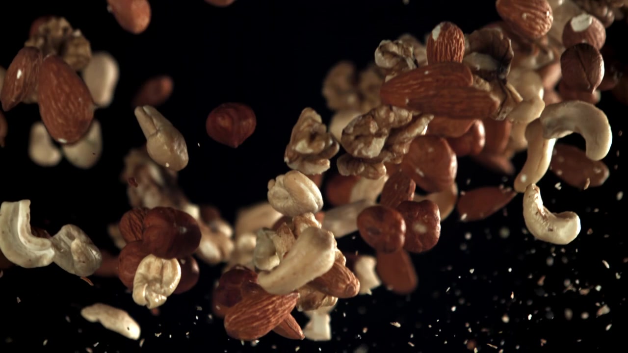 Mixed Nuts Falling in Slow Motion on Black Background