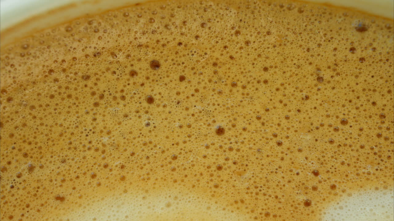 Close up of bubbles on a latte in a cup