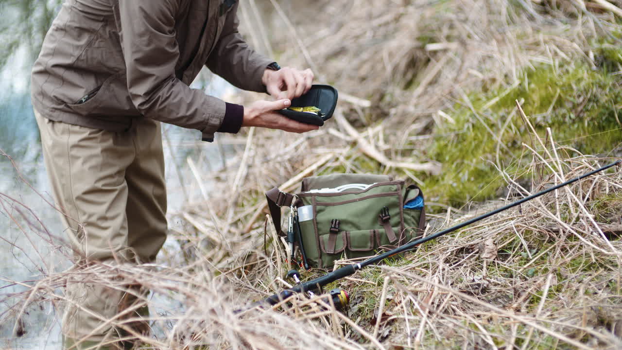 호숫가에서 낚싯대를 준비하는 자신감 있는 남자 4